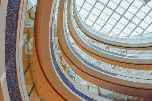 Elegant view of a shopping mall's balconies and glass skylight showcasing modern architecture.