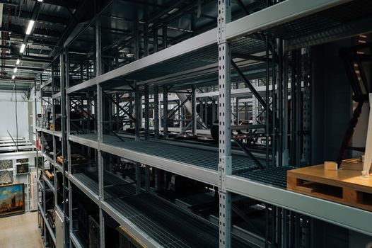 Empty metal storage racks in a spacious industrial warehouse setting.
