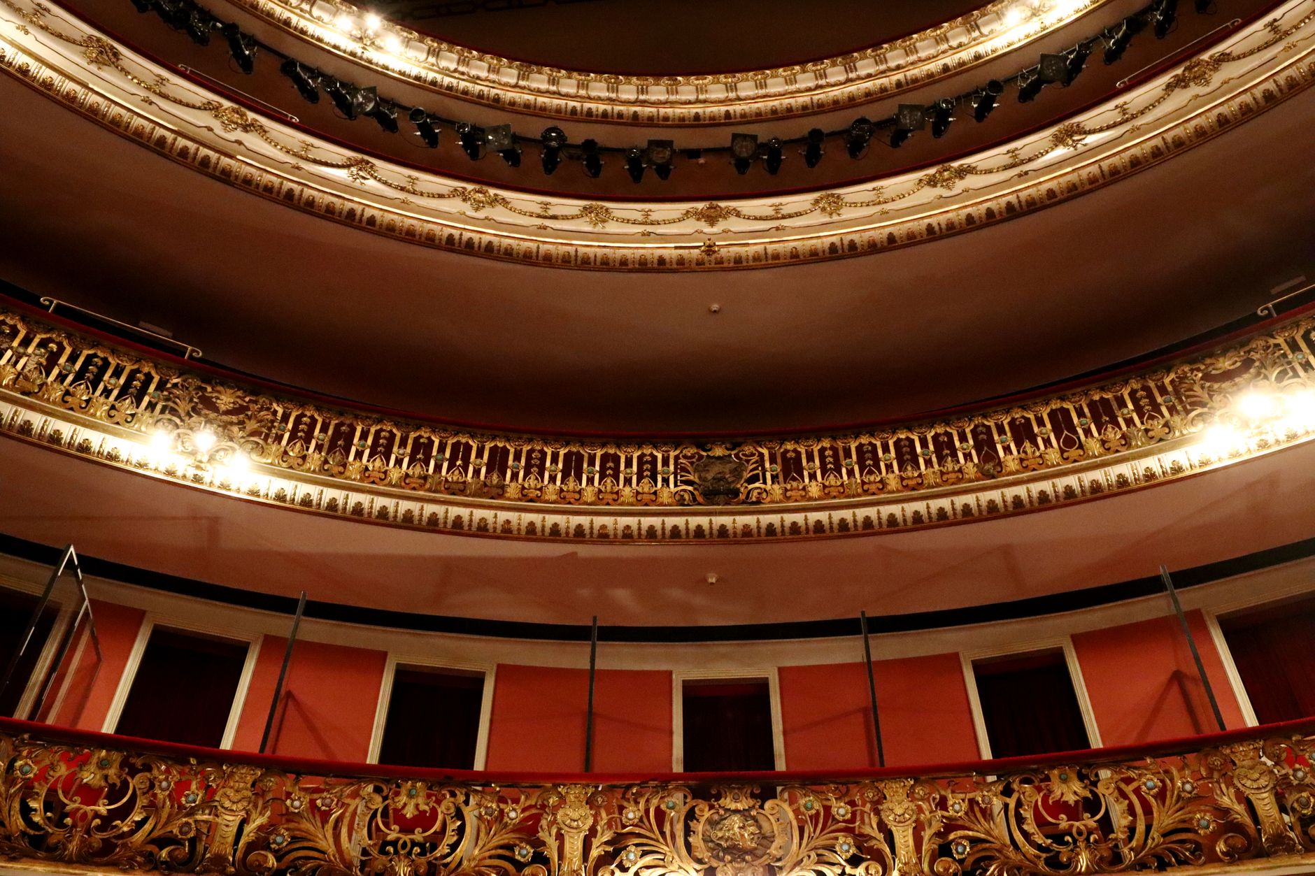 Richly decorated theater interior with gold details and dramatic lighting.